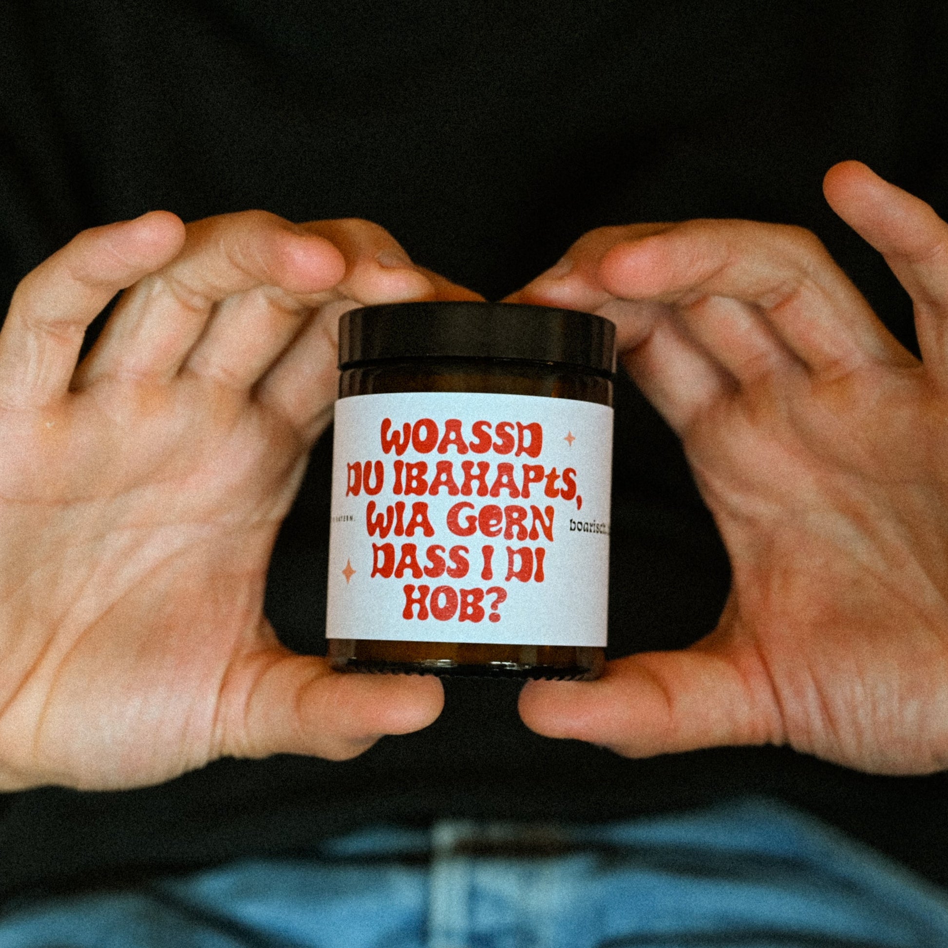 Jemand hält eine Kerze in die Kamera mit der Aufschrift: Woasst du ibahapts, wiea gern dass i di hob?