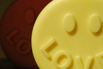 Nahaufnahme von zwei Kerzen in Smileyform und der Aufschrift LOVE